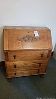 Full view of wooden secretary desk with drop front and three drawers, highlighting overall condition and design