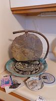 Photo of tarnished Moonshadow tabletop water fountain with basin filled with river stones and a curved metal water spout. Several small quartz stones and printed instructions also visible.