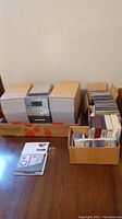 Philips MC-30 Micro Hi-Fi stereo system with two speakers placed on a table alongside boxes of CDs and cassette tapes.