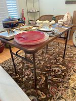 Photo showing folding table fully set up with various items on top to show size and surface.