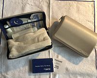 Two zippered toiletry cases and Air France playing cards on white cloth.