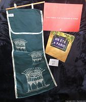 Photo showing the green cotton baguette bread storage bag decorated with white Art Nouveau Paris Metro entryway design, alongside the two books, 'Un été à Paris' and 'Louis Vuitton: L'art de traverser le temps'.