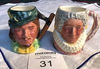 Front view of the two mini character jugs showing detailed facial features of Robin Hood and Queen Bess.