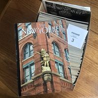 Box packed with approximately 88 issues of The New Yorker magazine from 2019 and 2020 with one issue on top showing a cover with a winter scene on a building corner.
