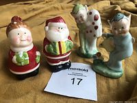 Four salt-and-pepper shakers: Santa Claus and Mrs. Claus, and two vintage garden pixies, one white with red spots and one blue.