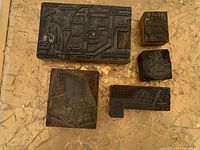 5 lead stamp print blocks on wooden bases depicting Industrial Revolution machinery and text details.