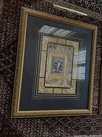 Large ornate gold antique frame with layered matting and classical musician artwork, showing overall condition and style.
