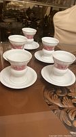 Five white Rudesheim style tea cups displayed together on a table.