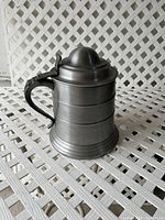 Front angled view of vintage pewtertone ice bucket stein showing lid and handle.