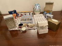 Displaying assorted collectible household items arranged on a table including boxes, glassware and ceramics.