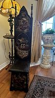 Full-height view of the black painted throne chair with pointed back and turned finials