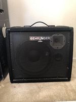 Front view showing Behringer logo and protective metal grille covering speaker.