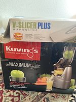 Box of Borner V-Slicer Plus Mandoline slicer on top of Kuvings juicer box