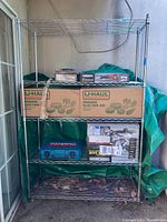 Full view of metal storage rack with items on shelves, showing overall structure and size.