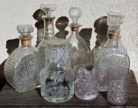 Group photo of 6 antique glass decanters with stoppers and 4 Victorian glasses showing various etched and pressed patterns.
