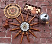 Full lot photo on brick surface showing all items including sunburst clock, copper wall decor, penguin ice bucket, carved wood tray, and wood candlestick.