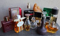 Wide view of the lot showing multiple vintage perfume bottles in various shapes, sizes, and colors including some with black, gold, and amber hues.