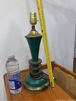 Green enamel and brass lamp base shown next to a water bottle for scale, lamp height approximately 17 inches