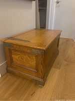 Side view of solid oak trunk with brass hardware and wooden panels