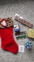 Photo showing all items together including the red stocking, Santa head floating candles, box of white floating candles, green Christmas tree candles, blue tea lights in jar, and cinnamon stick candles.