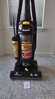 Front view of Eureka Whirlwind Lite Speed vacuum showing the clear dust bin with Spin Duster label and allergen filtration text on side.