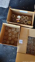 Three boxes of 16 ounce glass canning jars and new lids showing quantity and packaging.