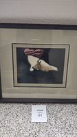 Front view of wood framed picture showing mountain sheep with double lined matte and visible frame nicks.