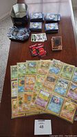 Full view on table with various Pokemon cards laid out, some sleeved cards, and Yu-Gi-Oh! cards stacked