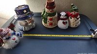 Overview of all five snowmen showing size and arrangement for scale measured against a tape measure