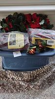 Five items together: three holiday garlands including one with red poinsettia flowers and berries, one swag decorated with poinsettias and berries, one candle ring, and two decorative floral picks with small white berries.