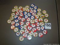 Photo showing large assortment of hockey tokens with varied rim colors and player images spread on flat surface.