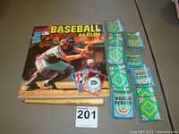 Full view of 1982 baseball sticker album with stickers, Mickey Mantle pen, and World Series cards arranged around album