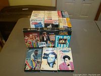 Lot of multiple Elvis Presley VHS tapes spread on a table, showing titles and artwork.