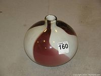 Front view of large round vase showing swirled pattern with alternating white and deep reddish-brown colors and narrow neck
