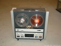 Full front view of the RCA reel-to-reel tape recorder with two reels mounted and the lid on top.