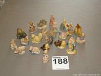 Photo showing the complete lot of 23 different Red Rose Tea Wade figurines arranged on a table, exhibiting a variety of nursery rhymes and animal figures in colorful glaze.