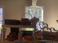 Wicker and apple baskets on two-tier metal shelving unit near windows with natural light.