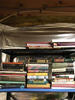 Bookshelf with assorted books showing various titles including cookbooks, encyclopedias, fiction, and reference books