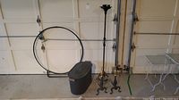 Photo showing the wood holder, metal container, and standing candlestick against garage door.