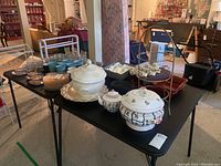 Full lot overview showing ceramic and glassware items on black table