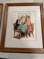 Framed Norman Rockwell print of couple at table with man holding newspaper