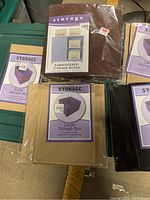 Five fabric storage boxes including four individual large storage boxes in different colors and one unopened pack of 4 embroidered small storage boxes.