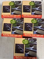 Four unopened boxes of Nantucket Lights Wall/Step Solar Light 2PK shown stacked together.