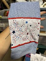 Light blue towel with star pattern fabric strip held stretched to show design