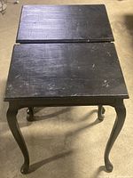 Top view of the two black wooden accent tables showing rectangular tops with scratches and surface wear.