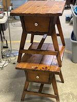 View of two stacked wood accent tables showing the design with drawer and lower shelf