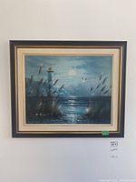 Full view of the framed acrylic painting showing lighthouse, water, tall grasses, and seagulls under a cloudy sky with sun or moon.
