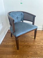 Front angle view of cane backed upholstered chair with blue seat and back cushions