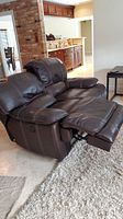Side angle view showing the left side electric recliner extended, revealing footrest and plush cushions.
