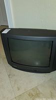 Front view of black Toshiba CRT television with curved screen and front controls.